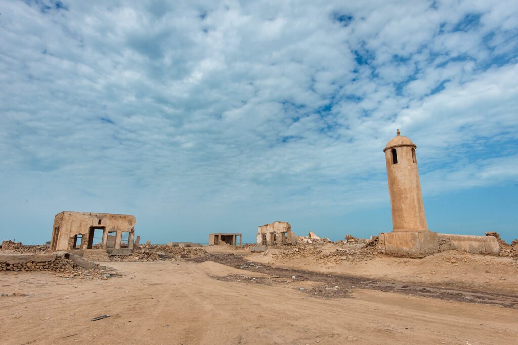 Crumbling walls around the old central square of Al Arish, with the minaret on the right