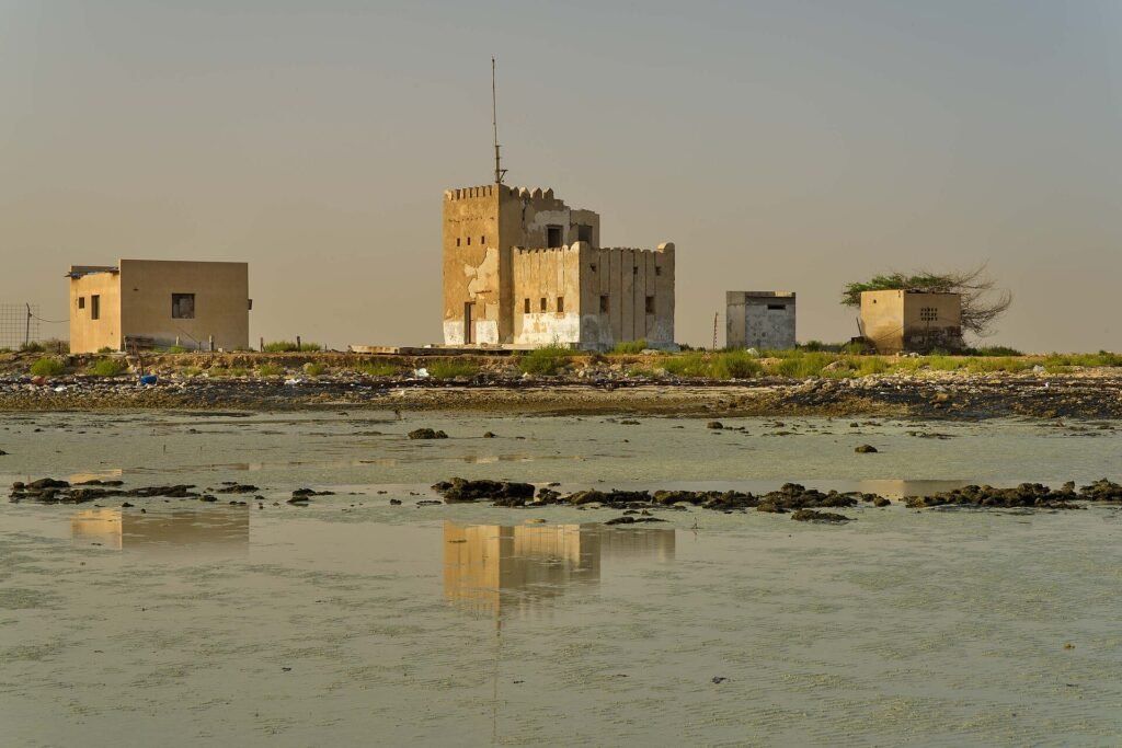 The abandoned police station at Al Arish reflected in shallow water