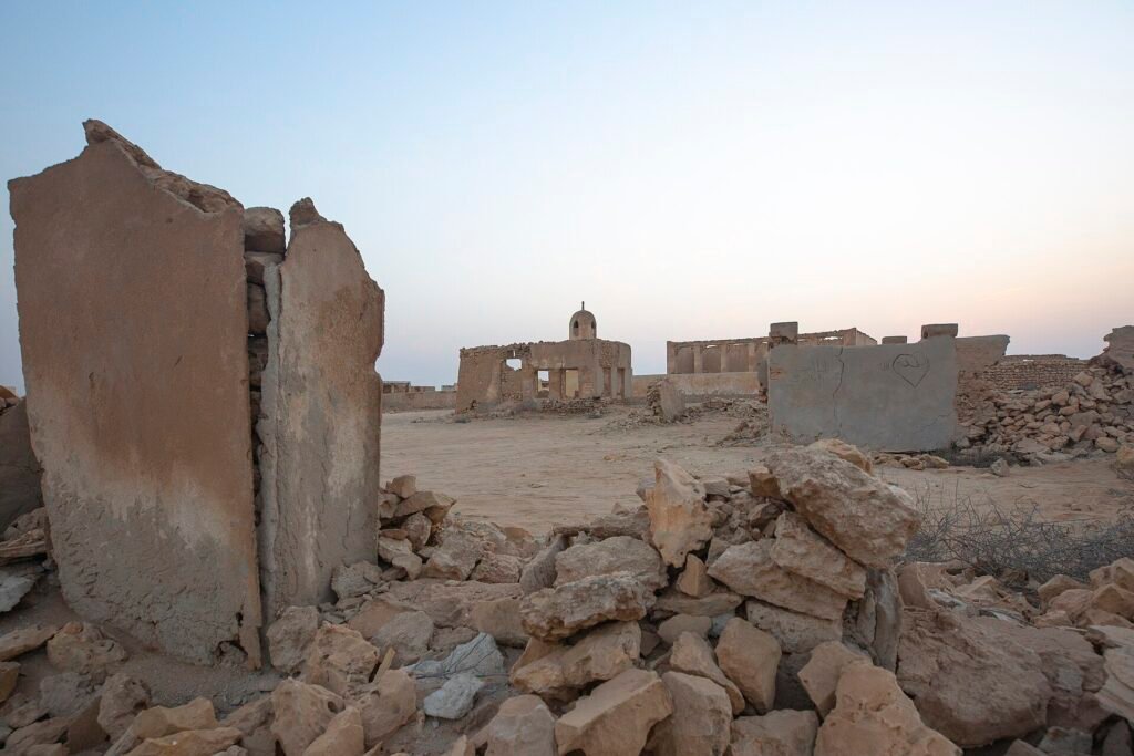 Collapsed stone walls of ruined houses at Al Jumail heritage village, Al Shamal