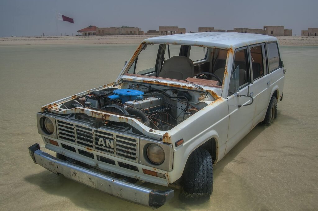 A stripped, abandoned 4x4 sitting on the tidal sand at Al Mafjar