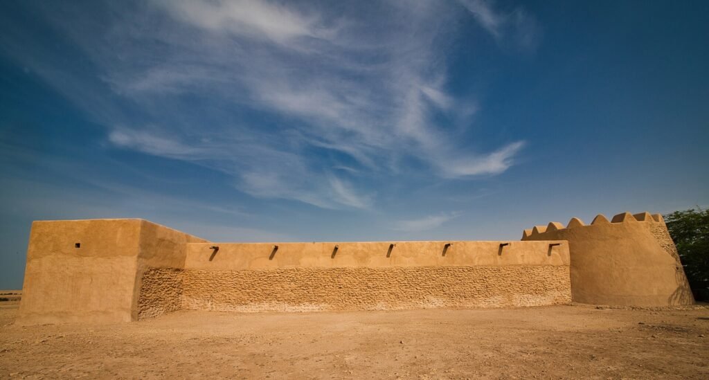 The long, low outer wall of Al Rakiyat Fort in the northern Qatari desert