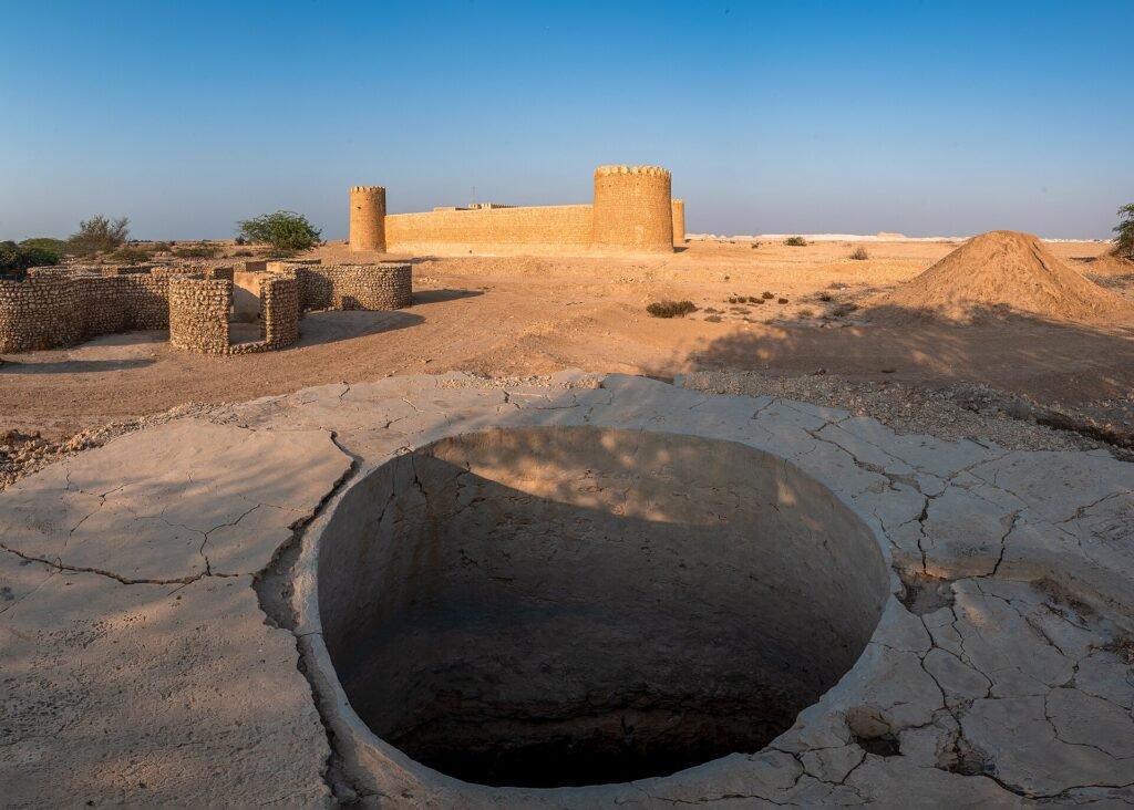 A large circular stone-lined pit in front of Al Thaqab Fort