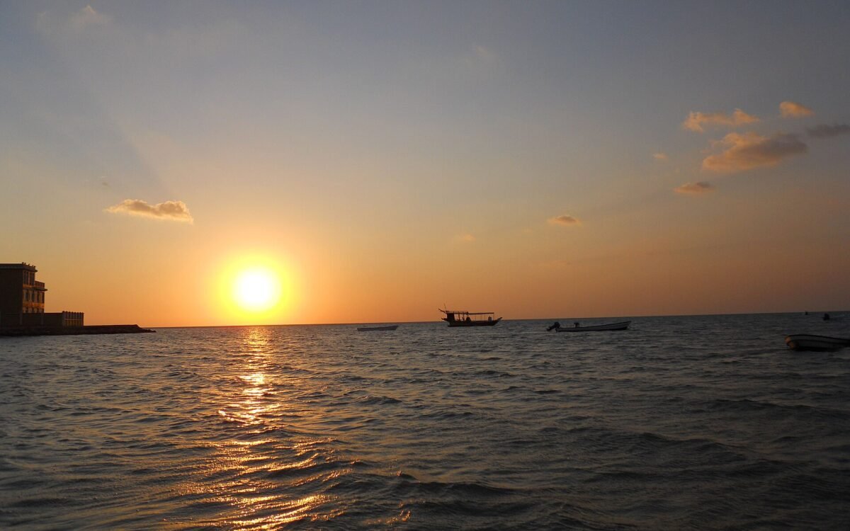 Sun setting over calm sea at a beach in Al Shamal, north Qatar