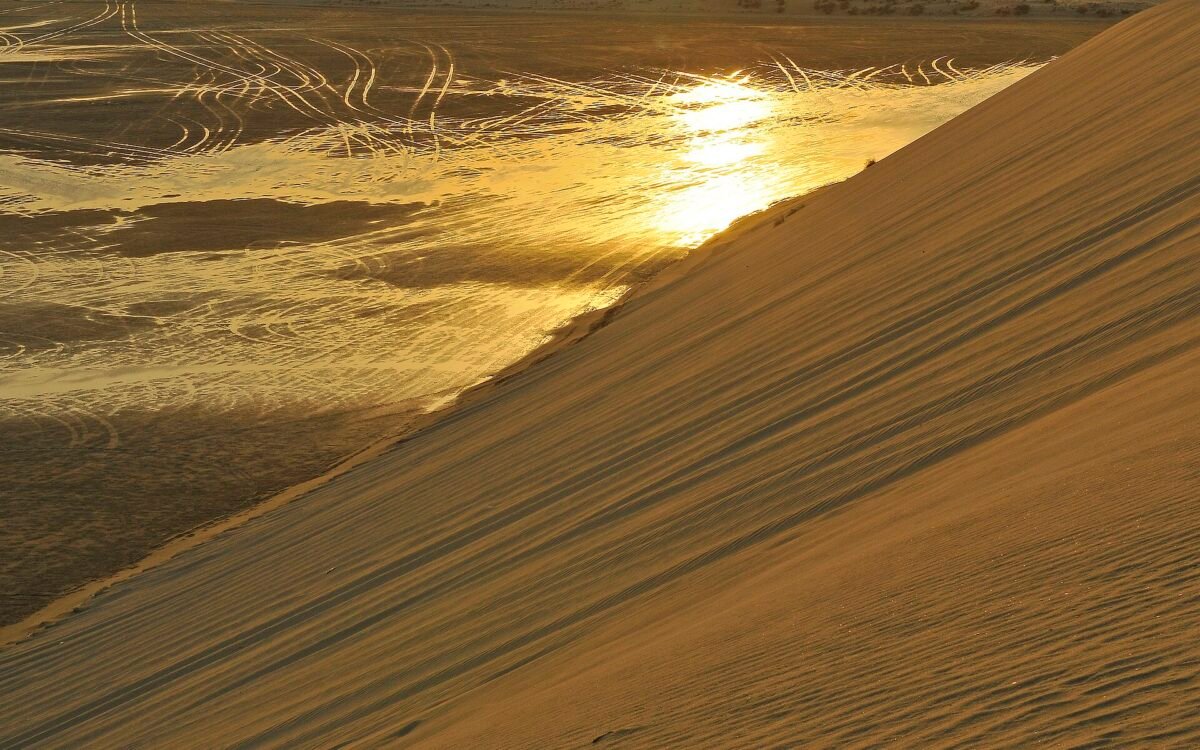 Golden late-afternoon light on a sand dune above the Inland Sea at Khor Al Adaid, southern Qatar