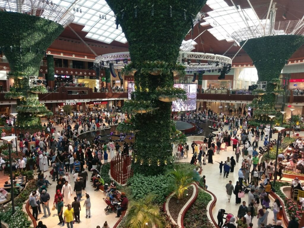 The Oasis atrium at Mall of Qatar, with its tree-like green columns and crowds on several levels