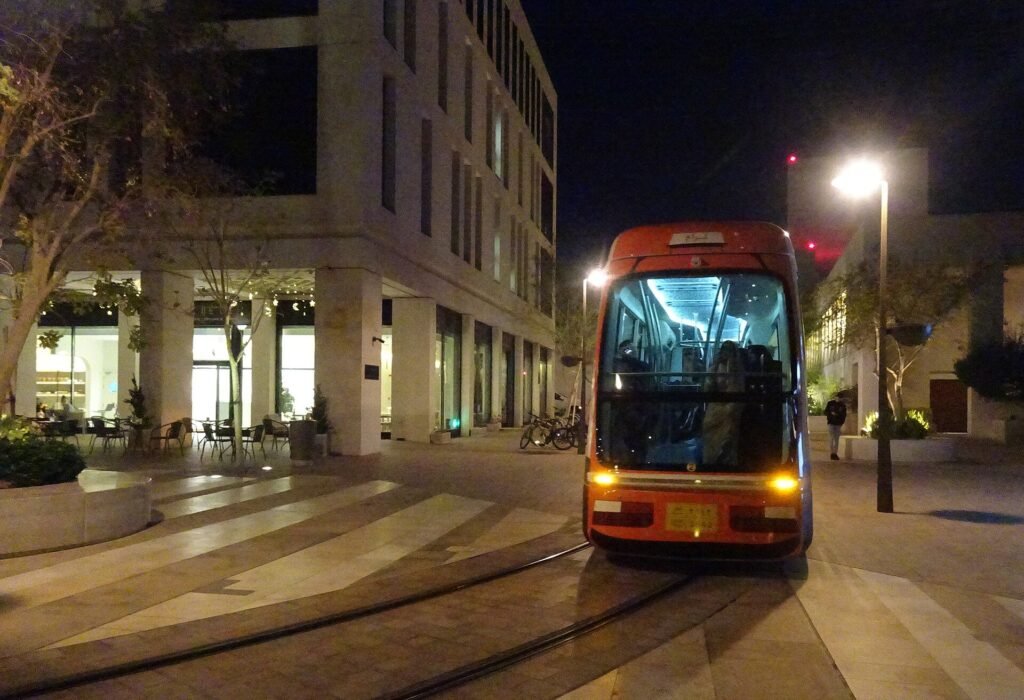 Msheireb tram on a lit street in Msheireb Downtown Doha at night