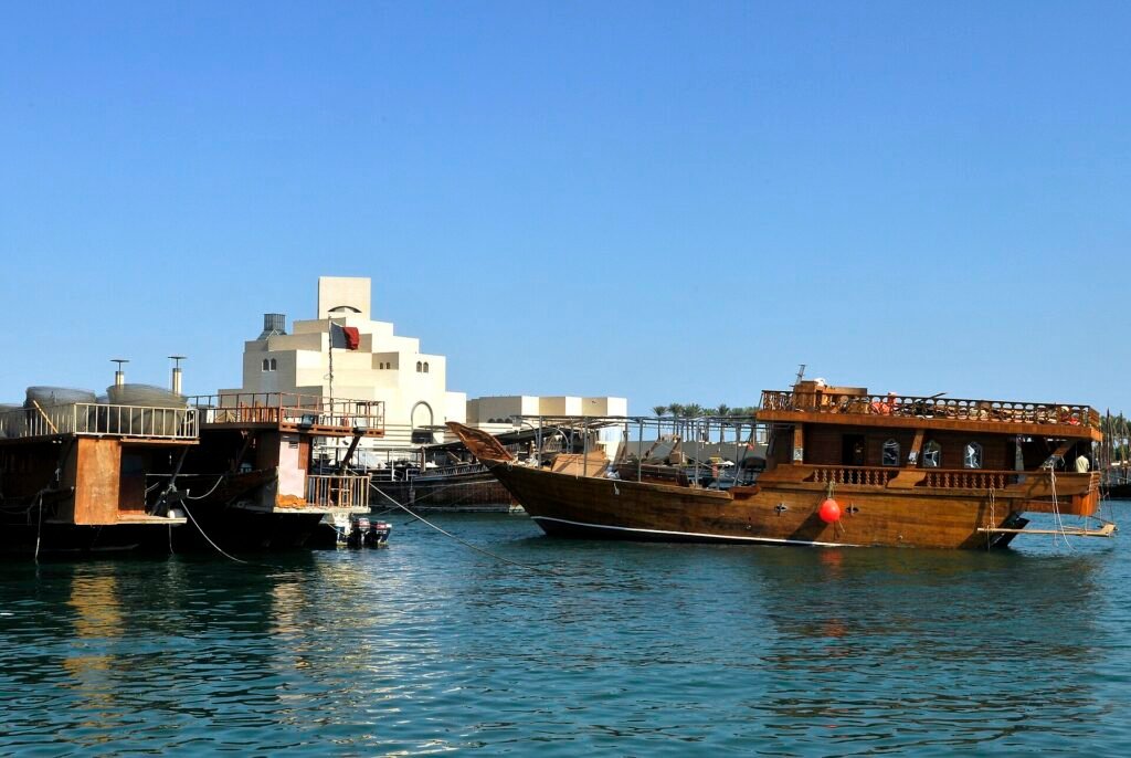 The Museum of Islamic Art seen across the water with wooden dhows moored in front, Doha