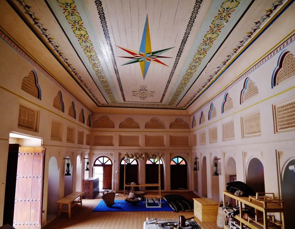 Painted wooden ceiling and arched windows inside a room of the Old Palace, Doha