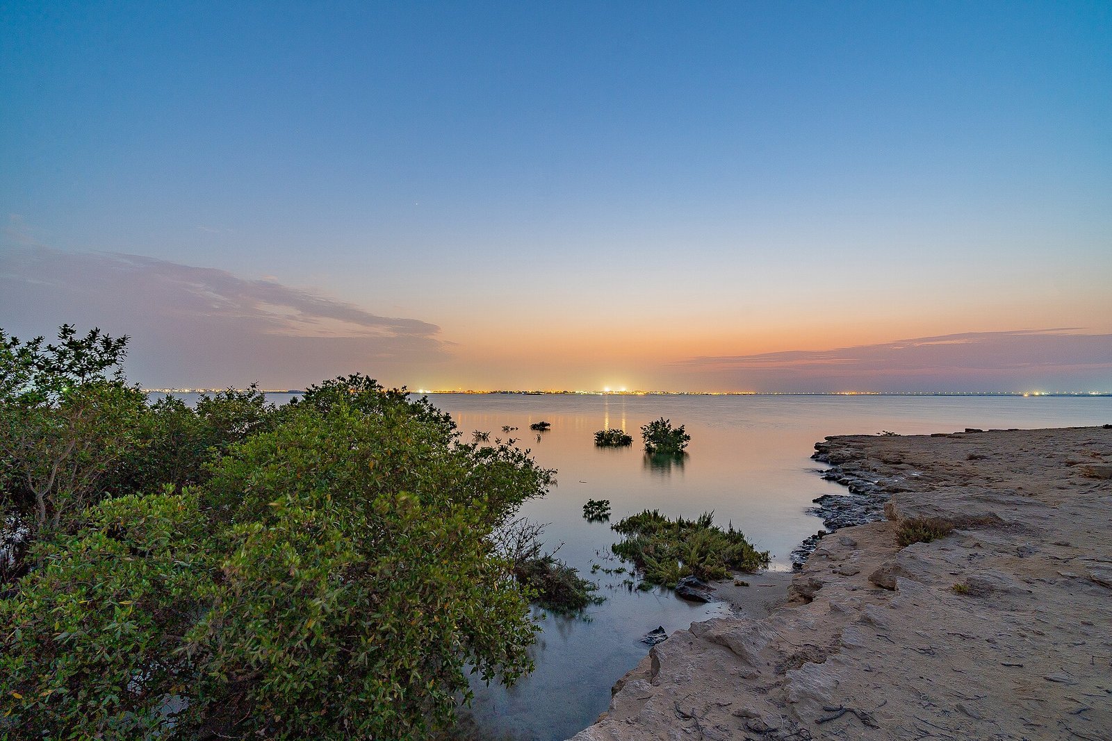 Sunset over mangroves and beachrock on the shore of Purple Island, Al Khor