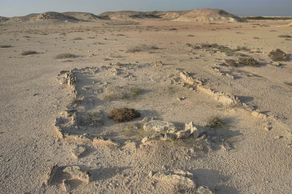 Low excavated archaeological site on the flat ground of Al Khor Island