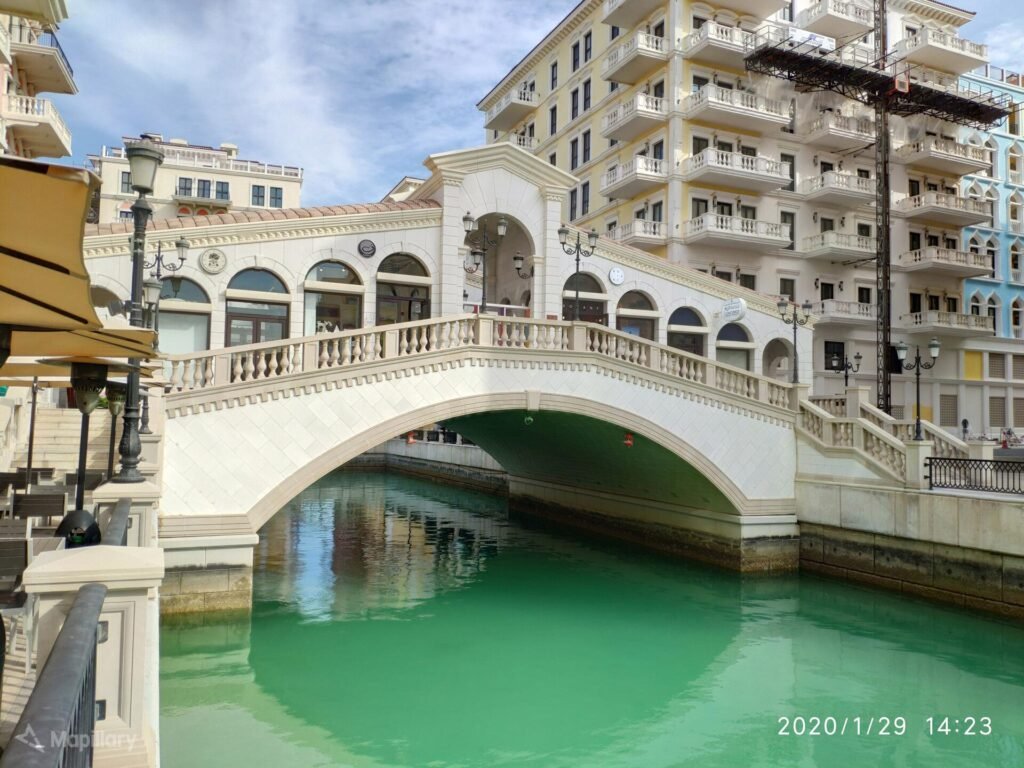 White arched pedestrian bridge over a canal in Qanat Quartier, The Pearl