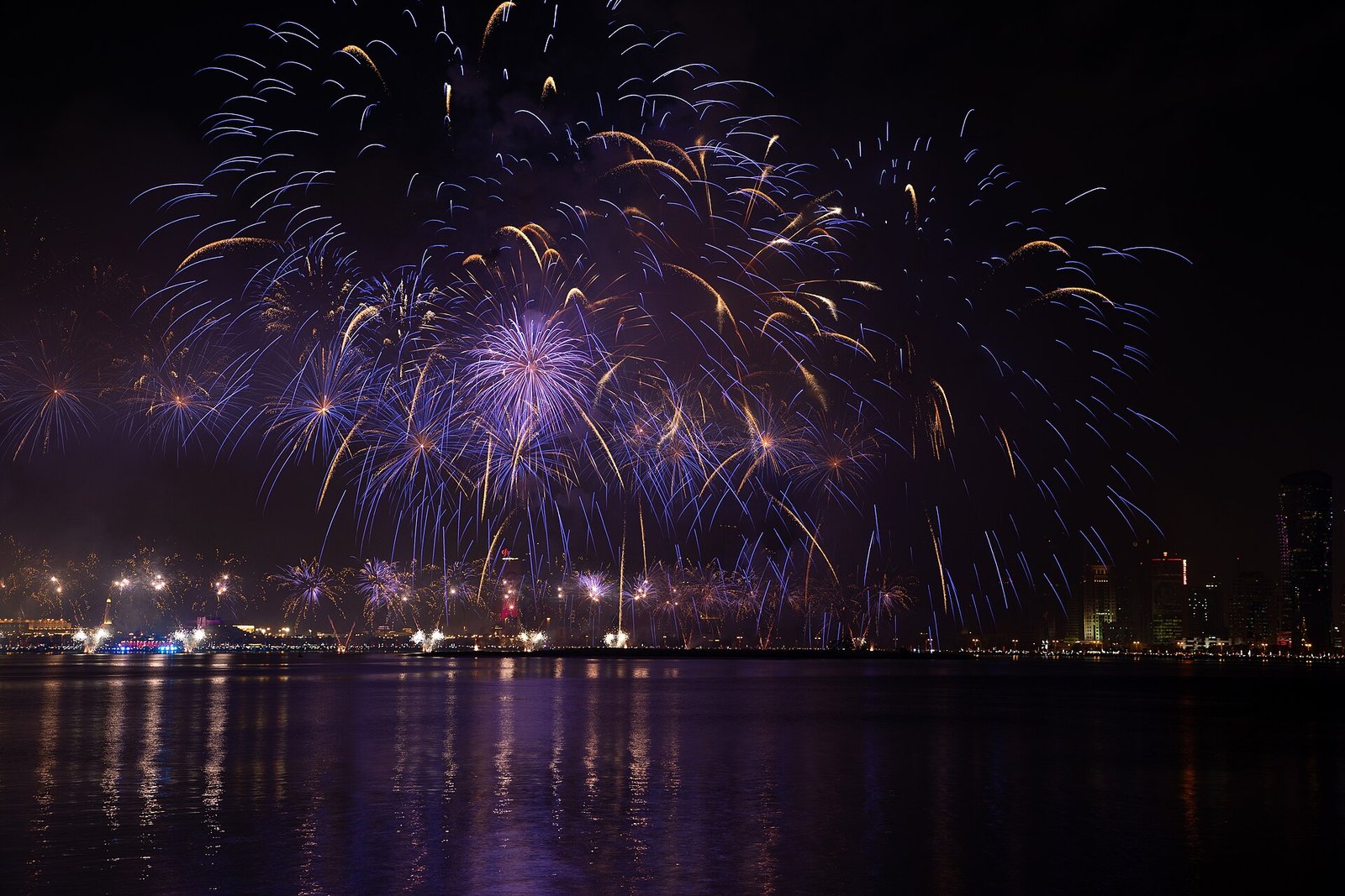 Purple and gold fireworks over the water in Doha on Qatar National Day 2018