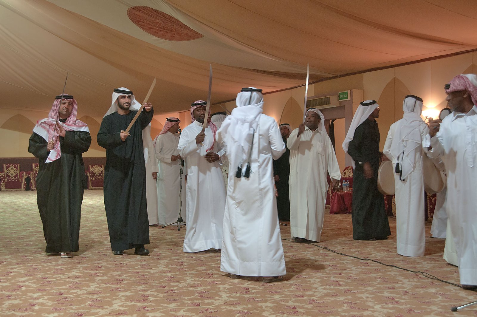 Men in thobes and bishts performing the ardah sword dance in Doha