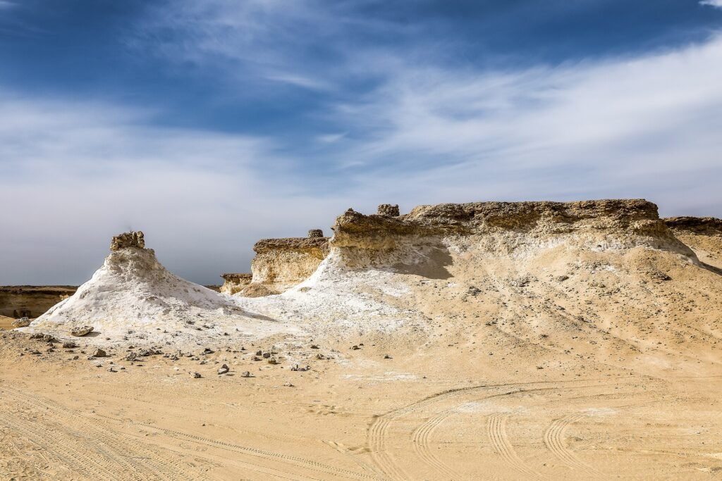Eroded white limestone outcrops under a blue sky at Ras Abrouq