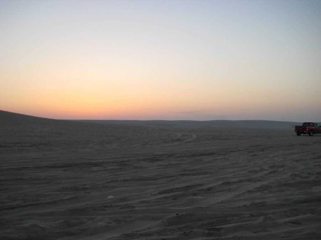 Sunset over the sea from the sands of Sealine Beach, south of Mesaieed