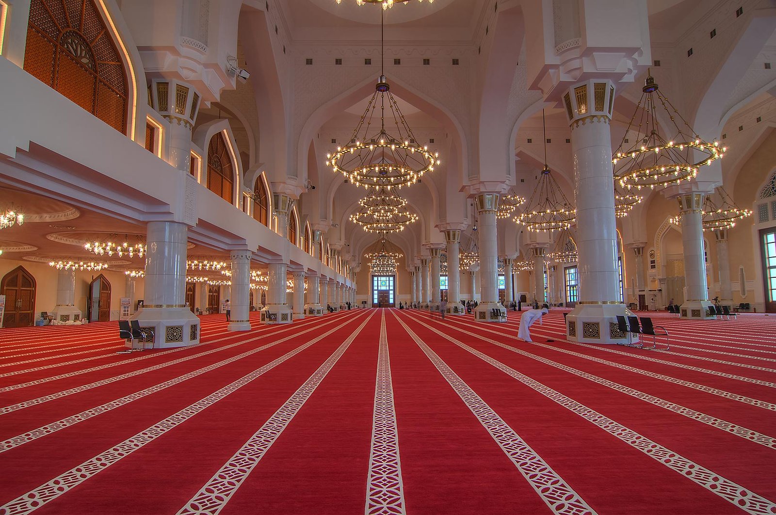 Prayer hall of the Imam Muhammad ibn Abd al-Wahhab Mosque with red carpet, columns and copper chandeliers