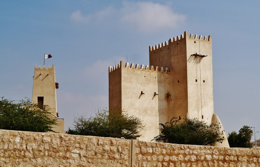 Twin towers of the Umm Salal Mohammed fortifications behind a low stone wall